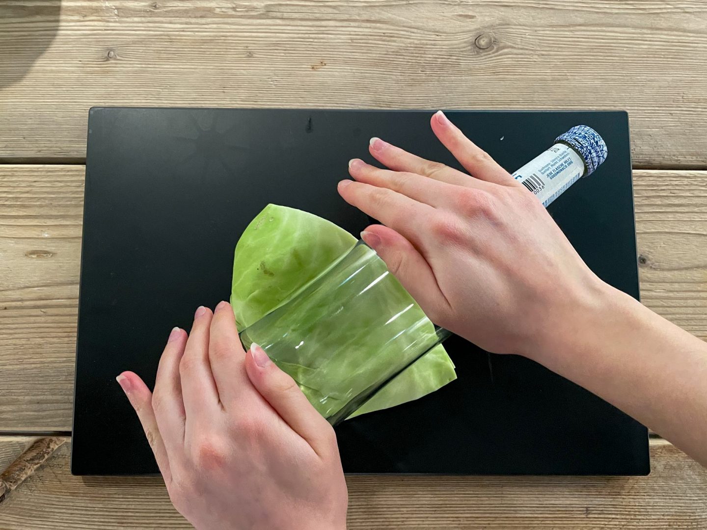 Weißkohlwickel mit Flasche rollen